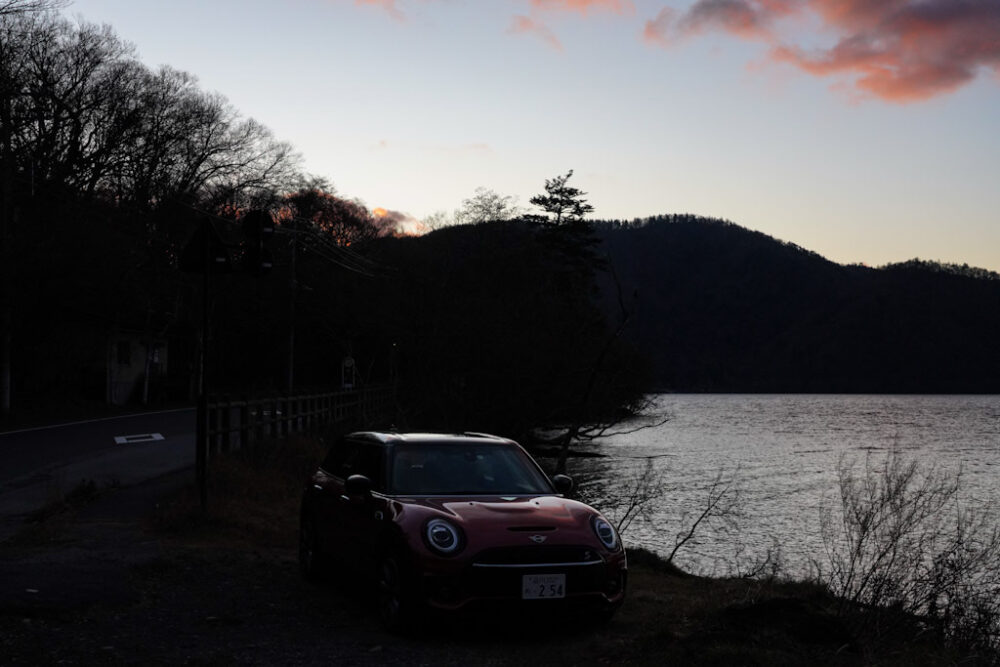 ちょうど日の出の中禅寺湖で撮影。車両は新型ミニ・クラブマン