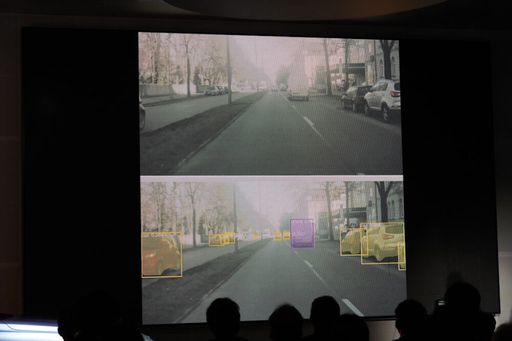 上の画像は人の目で見た映像、下は画像解析技術で車両を特定したもの。