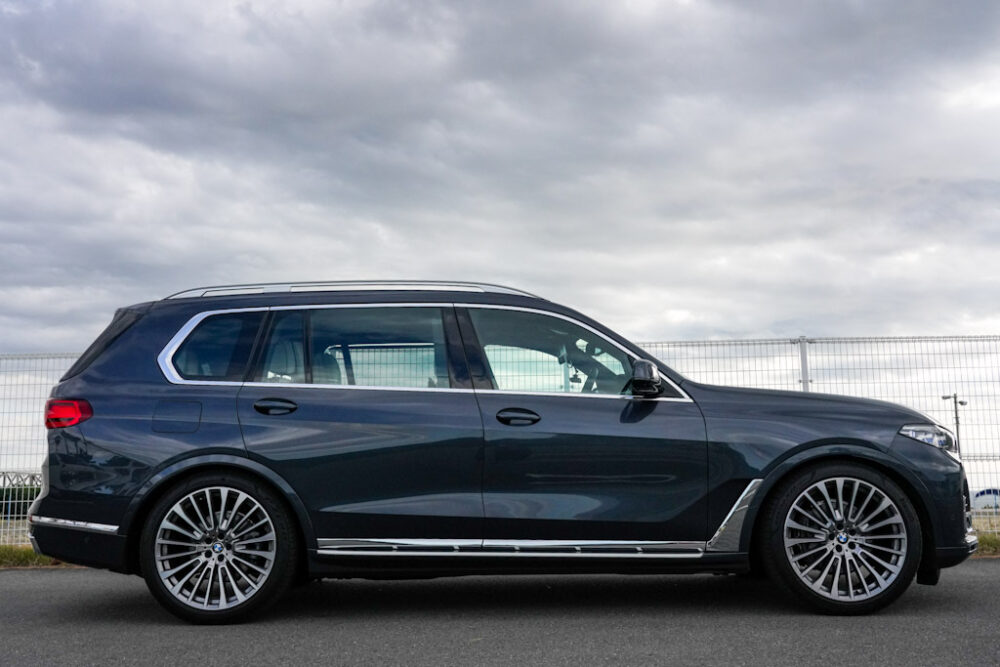 新型BMW X7 xDrive 35d デザイン・ピュア・エクセレンスのボディサイド。車高を下げた状態。