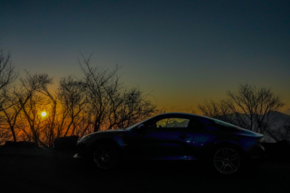 夕焼けの逆光でアルピーヌA110のサイドを撮影