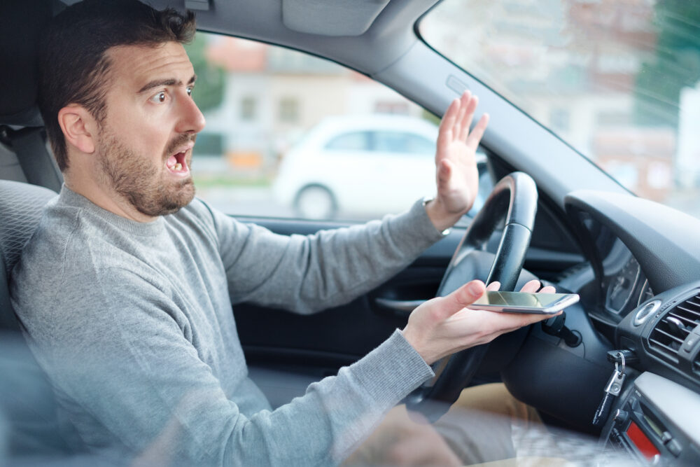 運転中にスマートフォンを使う男性