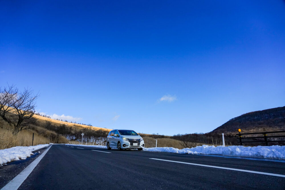 ホンダ オデッセイ ハイブリッド アブソリュート EX HondaSENSING 道端の雪が残る道を走る