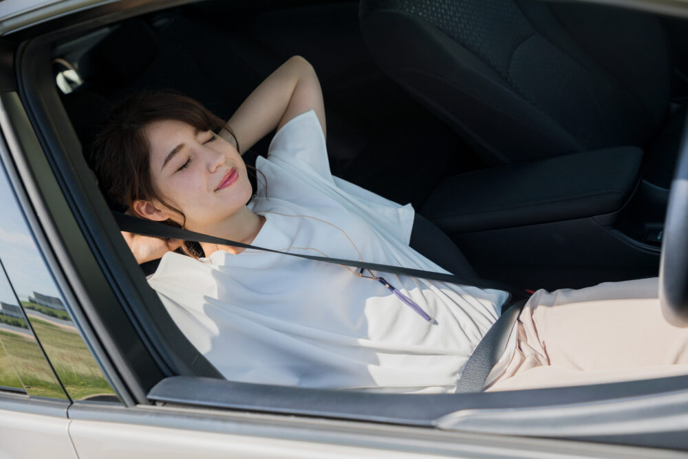 車の中で寝ている女性