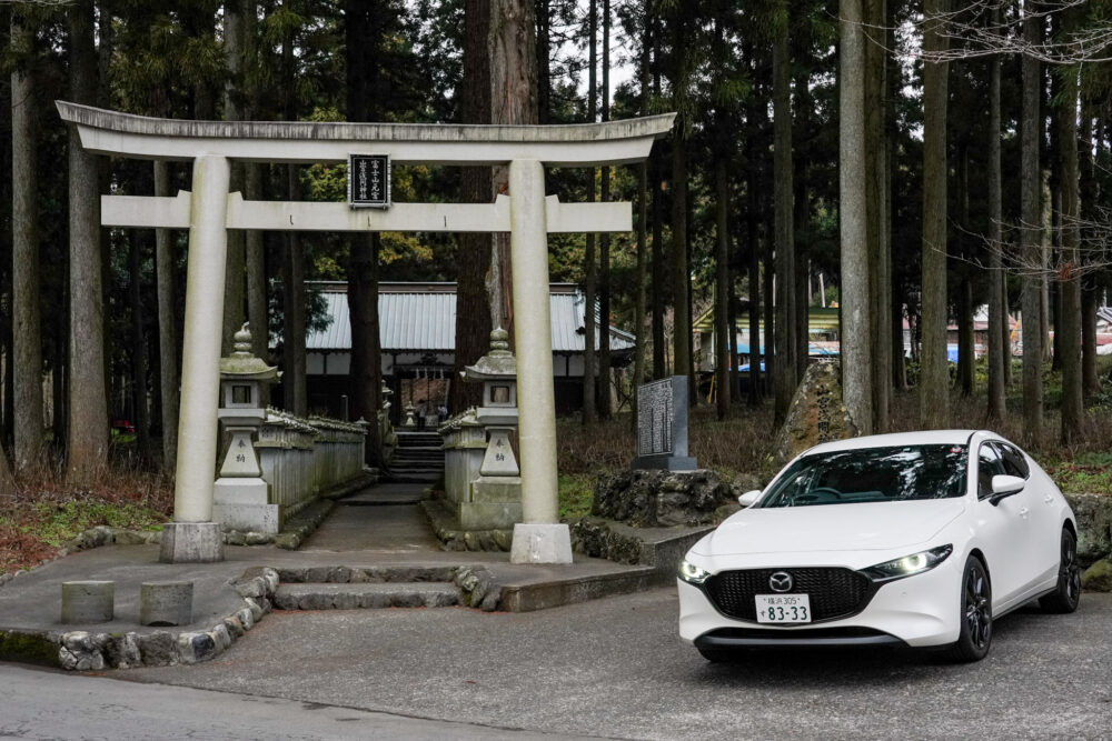 山宮浅間神社の2つ目の鳥居と駐車場に停まる白色のマツダ3ファストバック スカイアクティブX