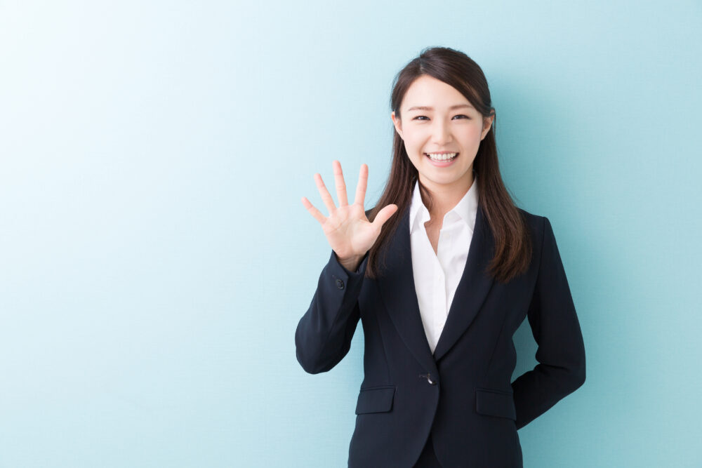 笑顔で手をかざす女性