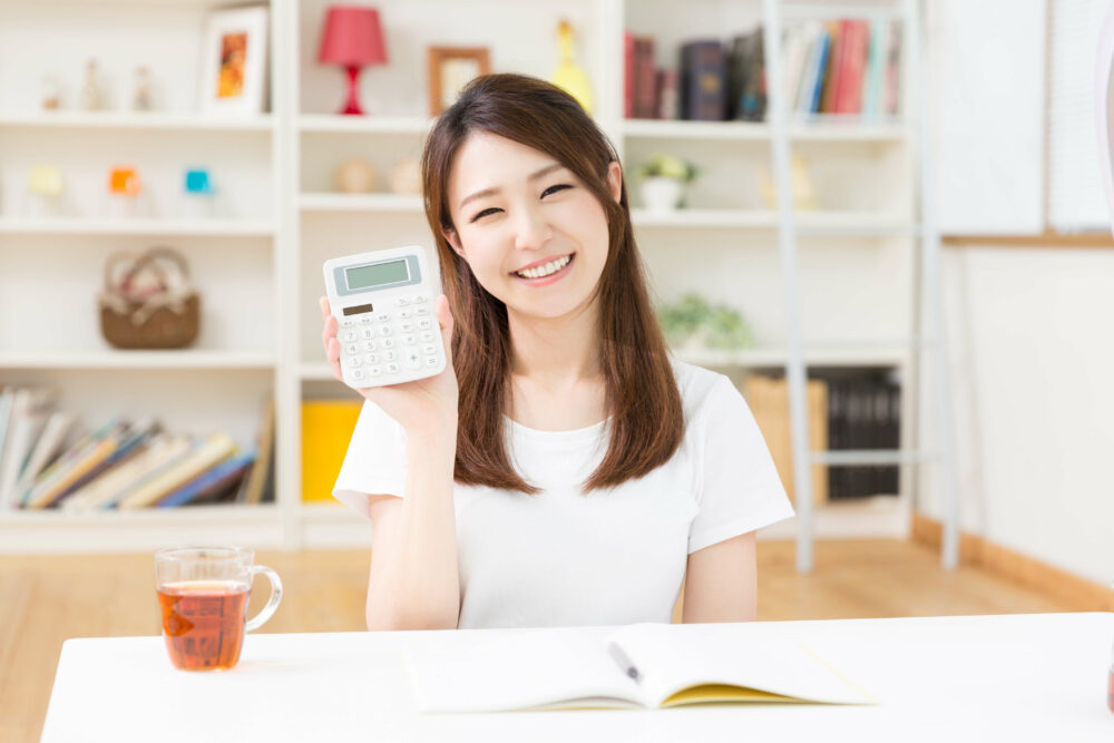 電卓を持つ笑顔の女性