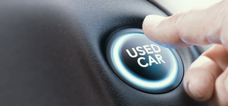 「USED CAR」と描かれたボタンを押そうとする手