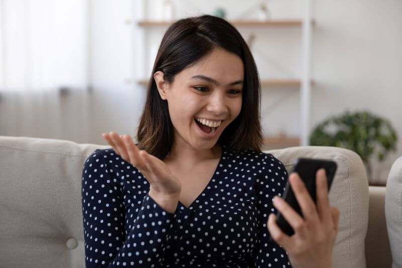 スマホを見て喜ぶ女性