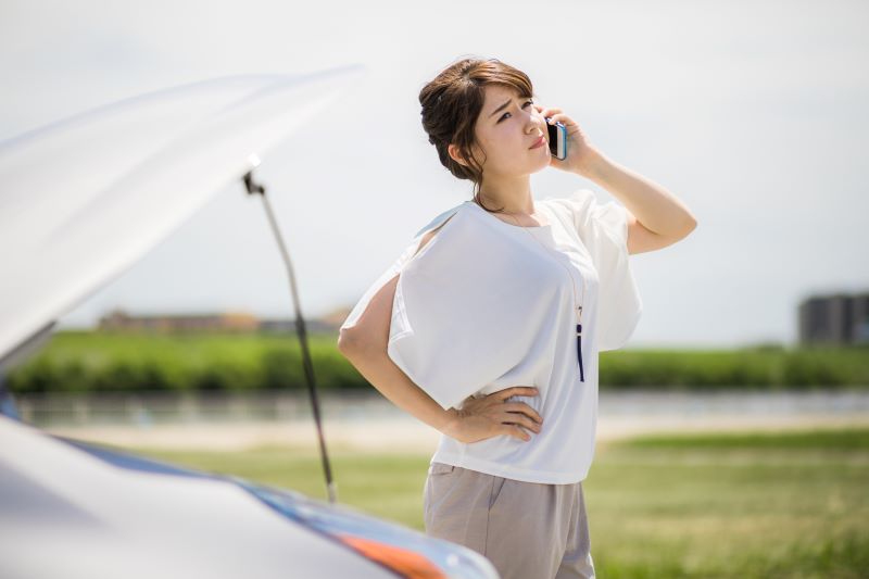 車と電話している女性
