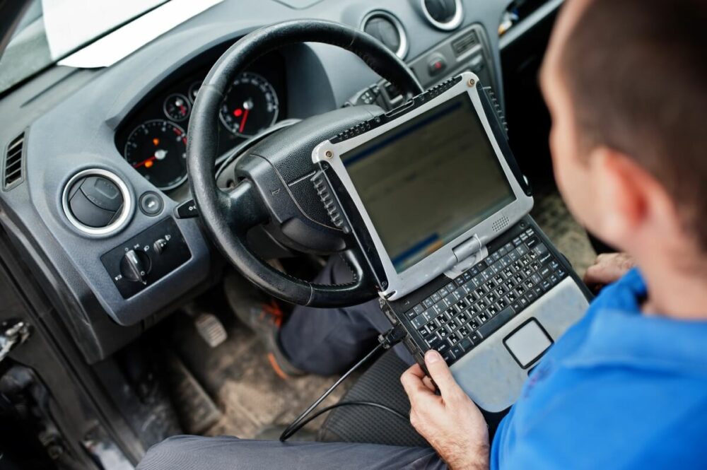 OBDデバイスを使って車両を修理する人のイメージ